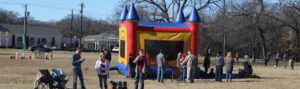 People around bounce house in a field